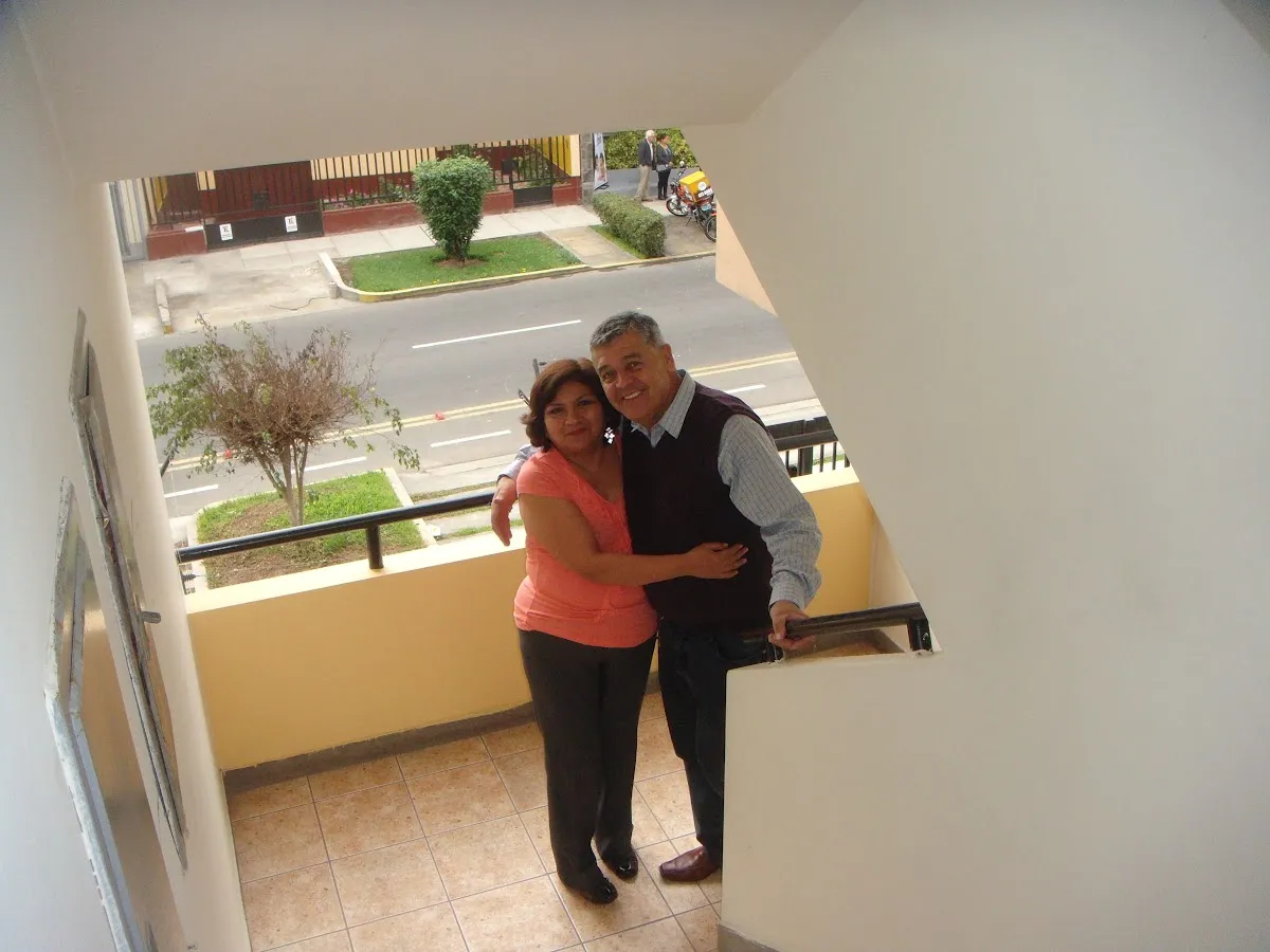 Mamá y papá posan abrazados en la escalera